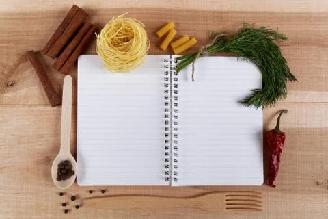 Baking ingredients for cooking and notebook for recipes on a wooden board. Stock Photos
