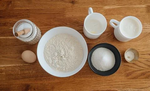 Baking ingredients, including flour, sugar, and butter, on a wooden table Stock Photos