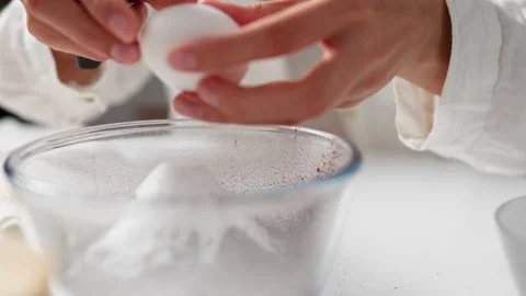 Baking ingredients on kitchen table with woman chef hands breaking egg. Bowl 動画素材 247367684
