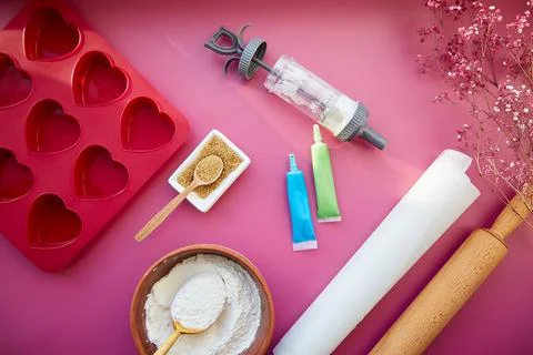 Baking kitchenware: heart-shaped silicone mold, rolling pin, confectionery Stock Photos