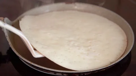 Baking pancakes in a frying pan on a kitchen stove at home on Shrovetide Stock Footage 171735672