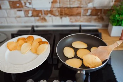Baking pancakes in modern kitchen. Steps of making cooking pancake at home. Stay Foto stock