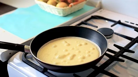 Baking pancakes in a pan. flip the pancake on the pan with a fork Video stock 105395825