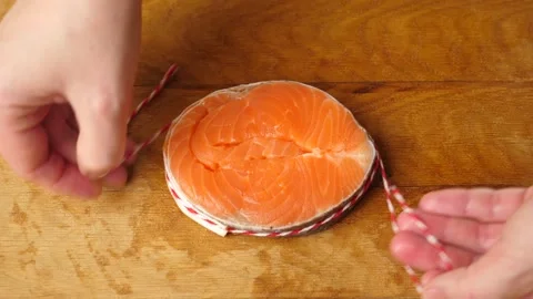 For baking, a piece of salmon is wrapped in a circle and tied with a string Stock Footage 263829561