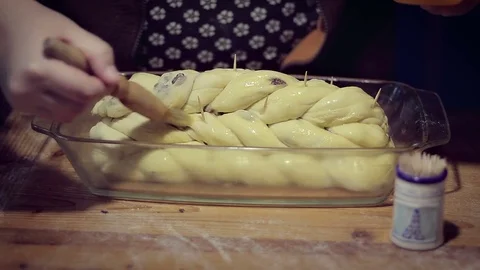 Baking Plaited loaf with raisins, coating with egg Stock-Footage 70988744
