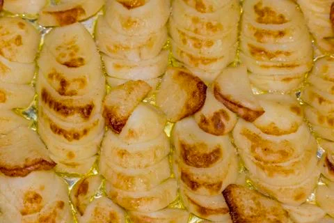 Baking potato chips on baking sheet in the oven. Stock Photos