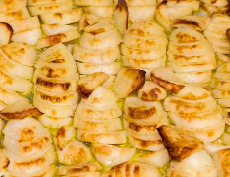 Baking potato chips on baking sheet in the oven. Stock Photos