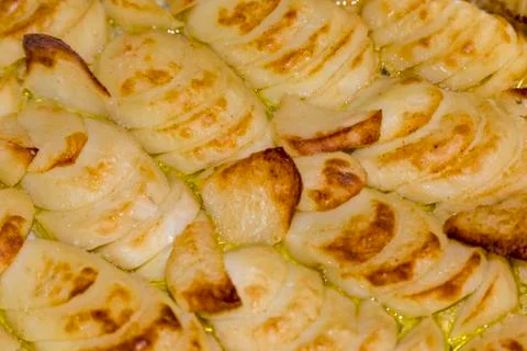 Baking potato chips on baking sheet in the oven. Stock Photos