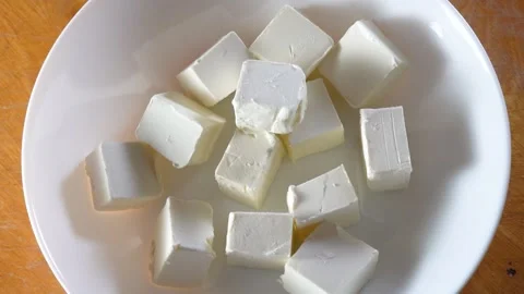 Baking process. Human hand putting cubes of butter, margarine into white plate Video stock 234405664