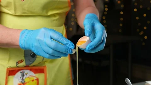 The baking process involves carefully cracking an egg Vidéo 295760359