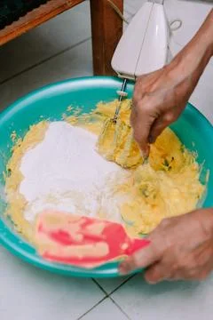 Baking process with mixer blending dough in bowl preparing cake Foto stock