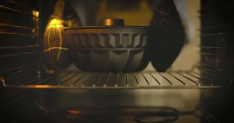 Baking process in an oven with a round baking dish in focus and warm light Stock Photos