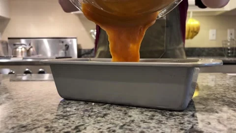 Baking Pumkin Bread Pouring batter into Bread Pan Stock Footage 320086598