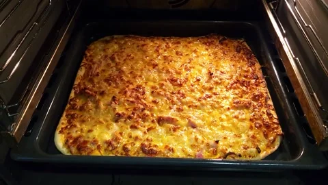 Baking a rectangular pizza in a baking sheet in an electric oven at home Stock Footage 240304619