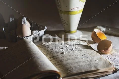 A baking scene with and old recipe book, eggs and flour Stock Photos