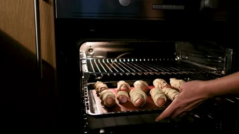 Baking sheet with hot dogs is placed in oven Video stock 164606603