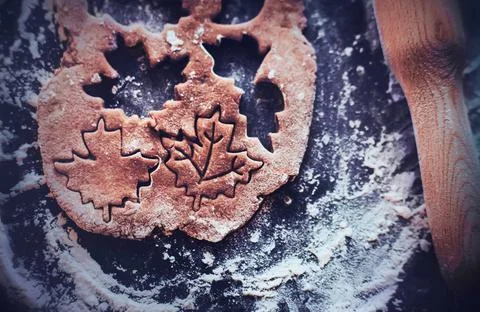 On a baking sheet, sprinkled with flour, there is a wooden rolling pin and do Stock Photos
