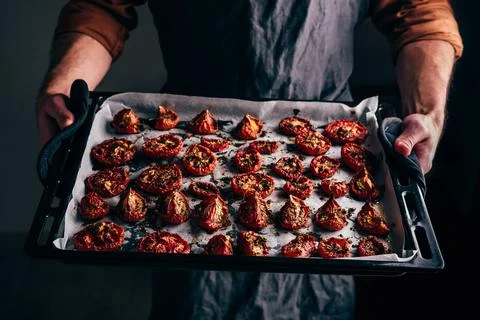 Baking Sheet with Sun Dried Tomatoes with Thyme in a Male Hands Stock Photos