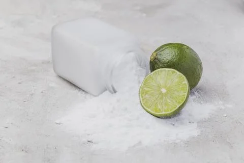 Baking soda and lime on a rustic surface Stock Photos