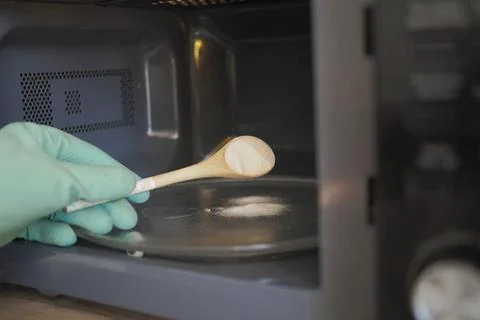 Baking soda being used to clean or deodorize the inside of a microwave oven Stock Photos
