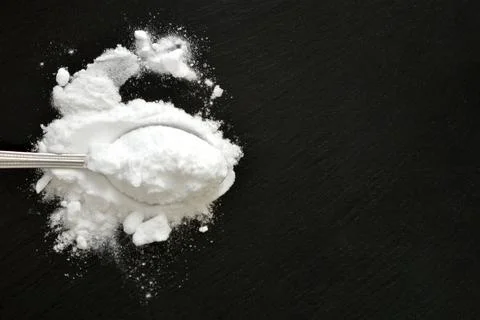 Baking soda on black background with copy space, flat lay Foto stock