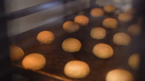 Baking sourdough bread rolls rising in the oven with a crispy golden texture Stock Footage 303404756