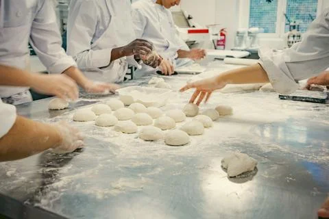 Baking students preparing fresh dough in a professional kitchen Stock Photos