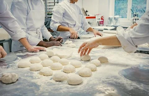 Baking students preparing fresh dough in a professional kitchen Stock Photos