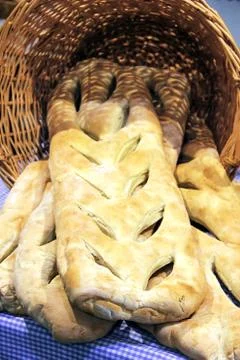 Baking theme image with a wicker basket full of homemade bread. Stock Photos