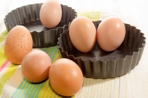 Baking tin and free range eggs on rustic wooden table Stock Photos