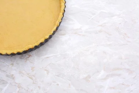 Baking tin lined with pastry on worktop Stock Photos