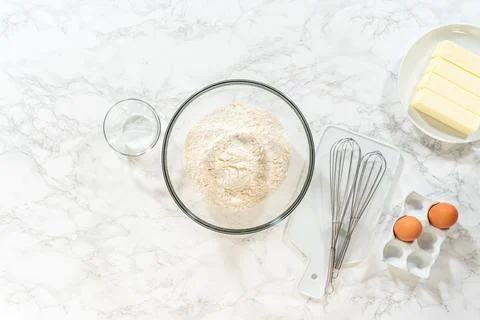 Baking tools and flour with eggs and whisk Stock Photos