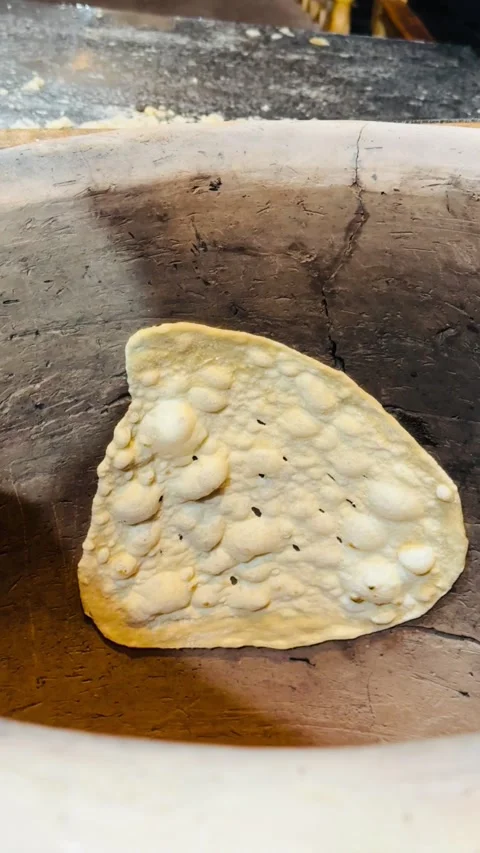 Baking traditional flatbread in clay tandoor oven, vertical view Stock Footage 345157047