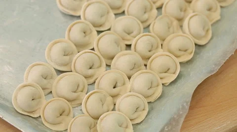 A baking tray with dumplings is standing on the table Stock Footage 58050141