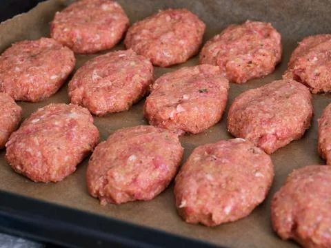 Baking tray with a raw cutlets ready to cook Stock Photos
