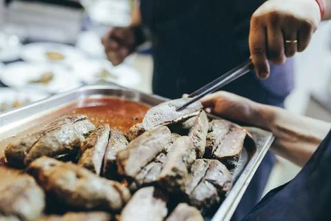 Baking tray with roasted meat. Take a piece of meat to taste. Stock Photos