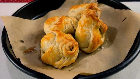 Baking tray rotating with three golden fresh baked brown wrapped in dough pears. Stock Footage 313047137