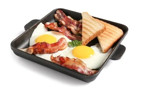 Baking tray with tasty fried eggs, bacon and toasted bread isolated on white  Stock Photos