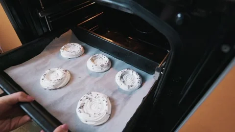 Baking Tray with White Raw Meringue Cookies Goes Into an Open Oven Stock Footage 334119082