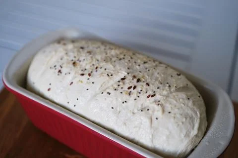 Baking of wheat bread: loaf in red ceramic form waiting for the oven. Stock-Fotos