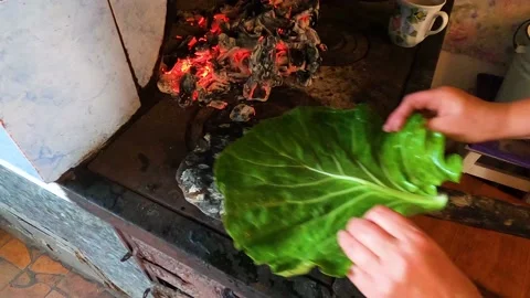 Baking yeast bread bread on a cabbage leaf using a traditional fire stove Stock Footage 135381960