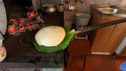 Baking yeast bread bread on a cabbage leaf using a traditional fire stove Stock Footage 135381974