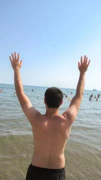 Baku, Azerbaijan, July 5 2020 : Young white caucasian man waving into the sea Stock Photos