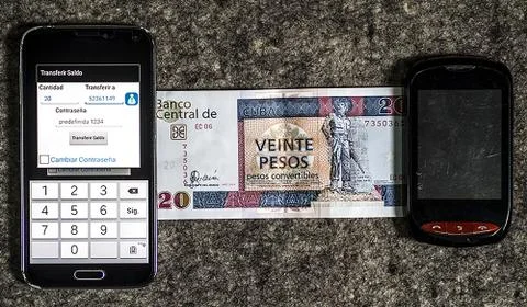 Balance transfer between two cell phones and a cash bill. Telecommunications Stock Photos