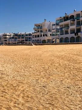 Balanced beachscape a harmonious blend of sand, buildings, and natural beauty Stock Photos
