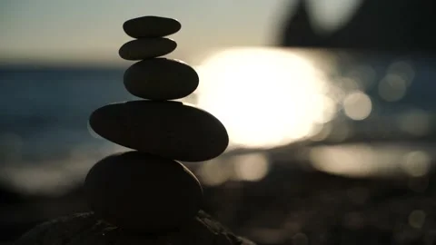 Balanced pebble pyramid on the beach on a sunny day. Abstract Sea bokeh from Stock Footage 153195572
