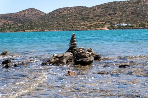 Balanced pebble rock tower cairn on the rocky seashore of Mirabello Bay in .. Foto stock