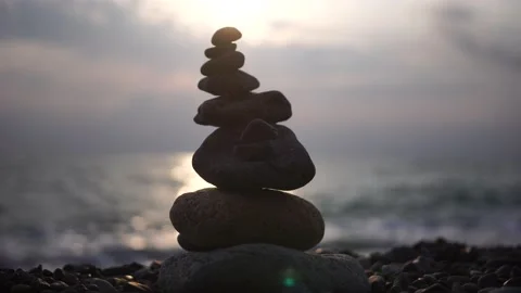 Balanced pebbles pyramid on the beach on cloudy day and clear sky at sunset Stock Footage 171445582