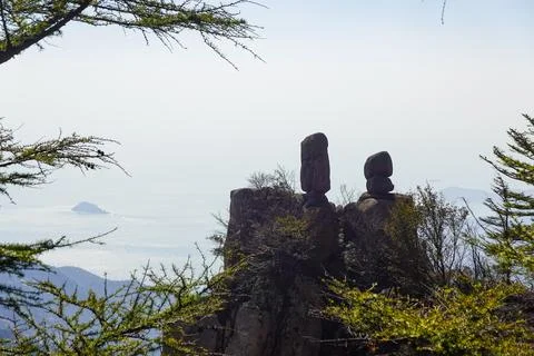 Balanced rock pair framed by conifer boughs Foto stock
