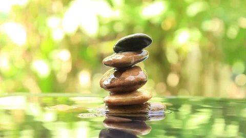 Balanced rock pyramid on water and Golden light bokeh on background 1 Stock-Footage 260200766